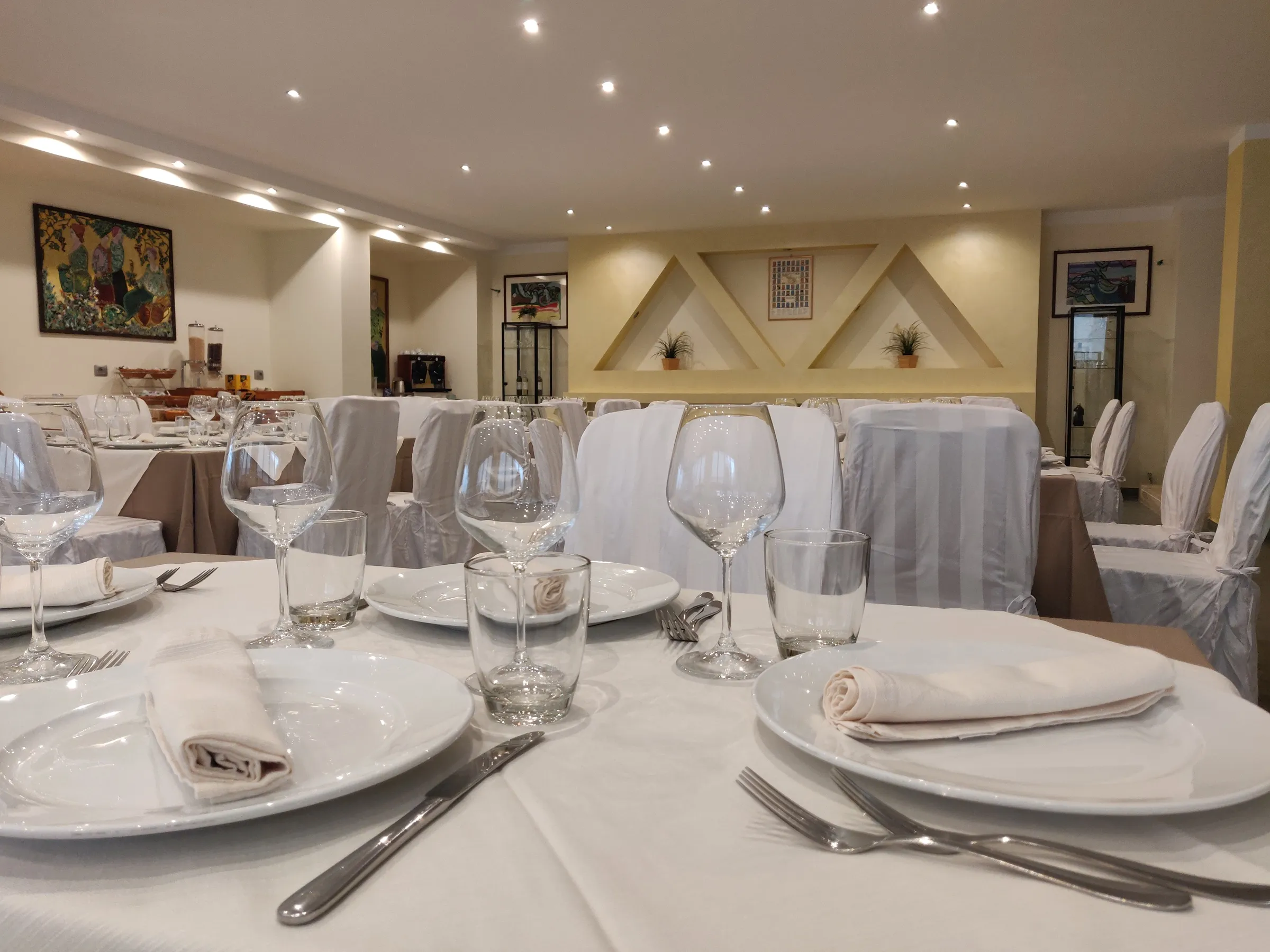 Sala del ristorante apparecchiata con tovaglie bianche