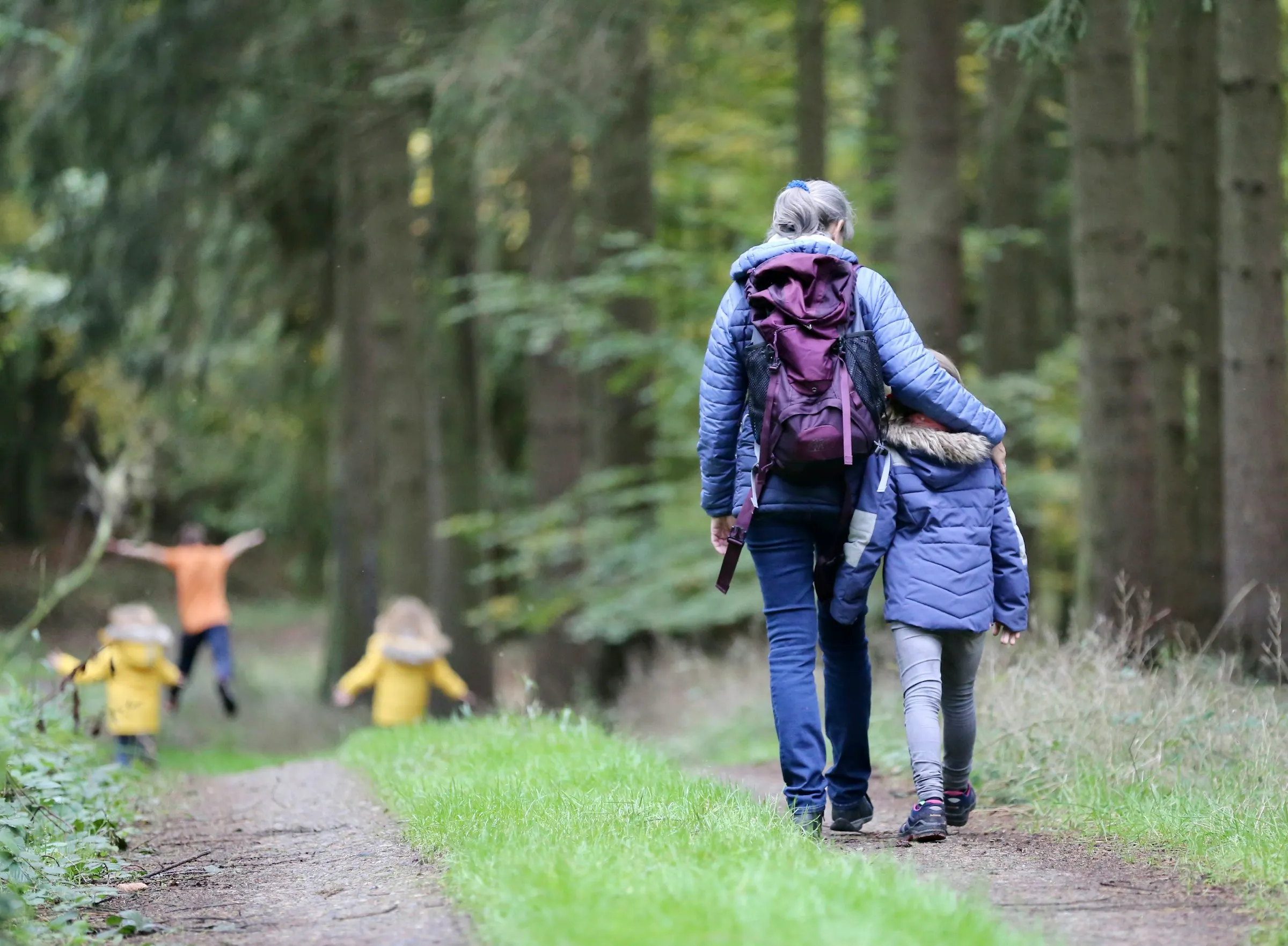 Bambini con lo zaino lungo un sentiero nel bosco