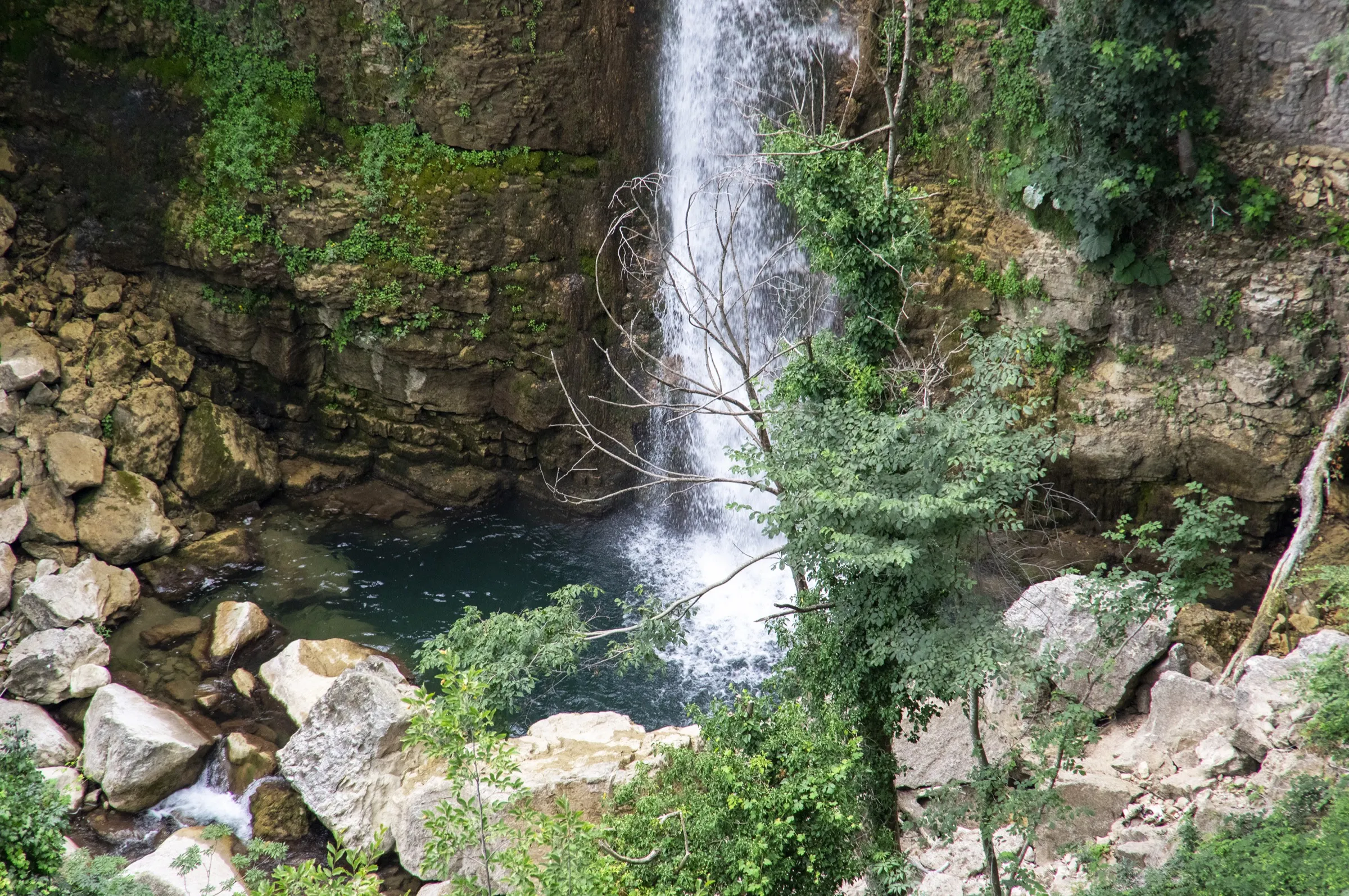 La base della cascata con la pozza d'acqua tra i massi
