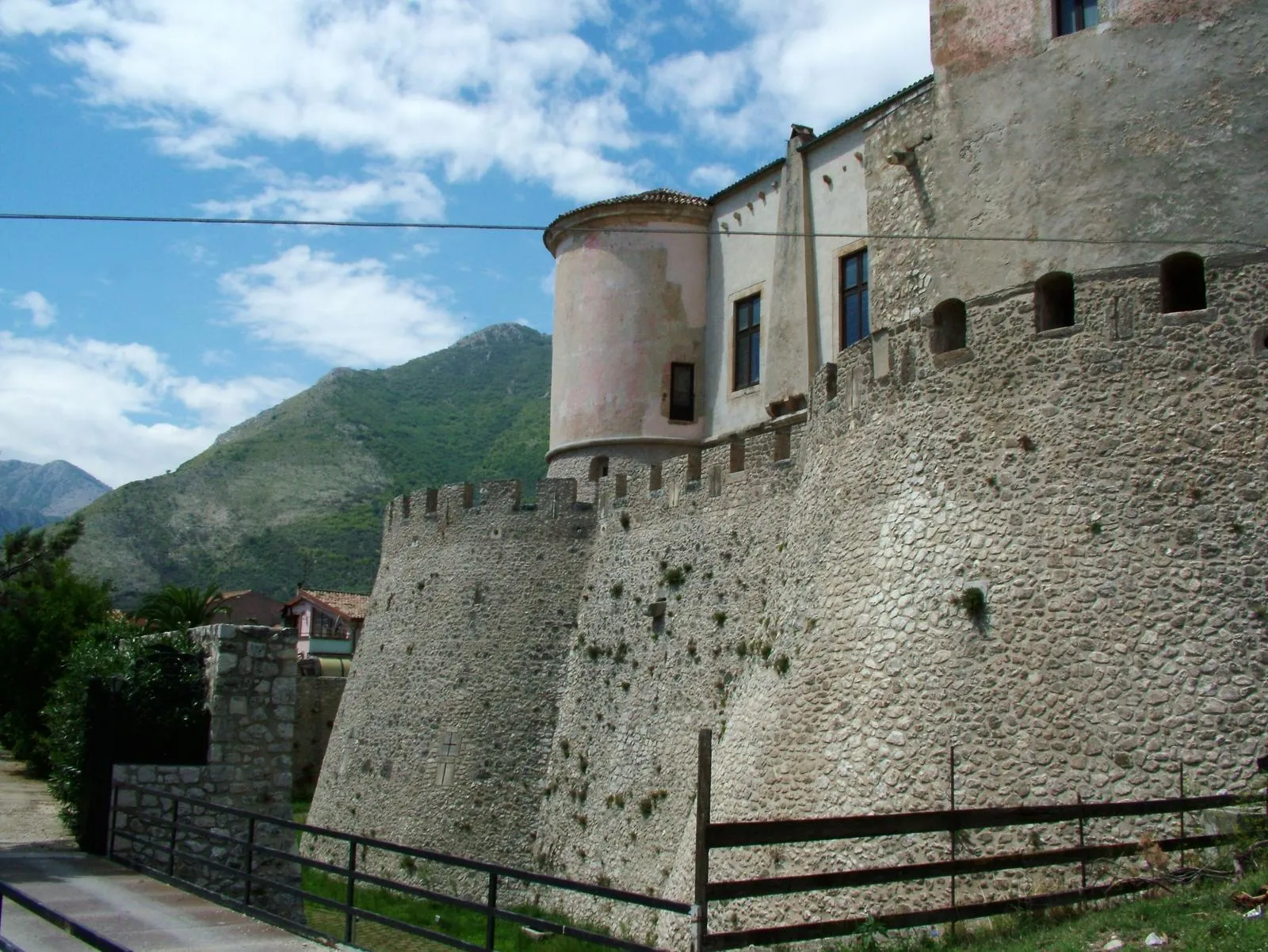 Le mura merlate e il torrione del Castello Pandone con le montagne alle spalle
